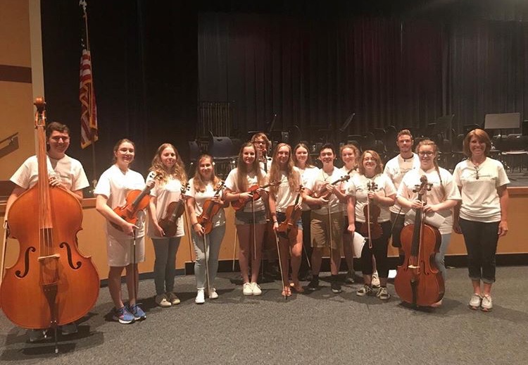 In a previous orchestra concert, members posed with their instruments for a picture. Orchestra has participated in many concerts. They perform in concert during the holidays as well.