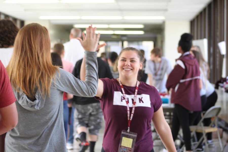 High five!  Senior Taylor Finochio high fives a fellow student. This was one initiative from the Friends of Rachel Club.