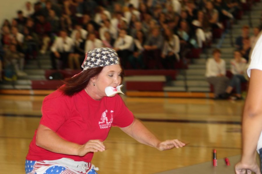 Pucker up
Carolyn Kline races to the finish with a playing card in her mouth during the assembly. Two teacher teams competed against each other using games the homecoming candidates would play the next week.