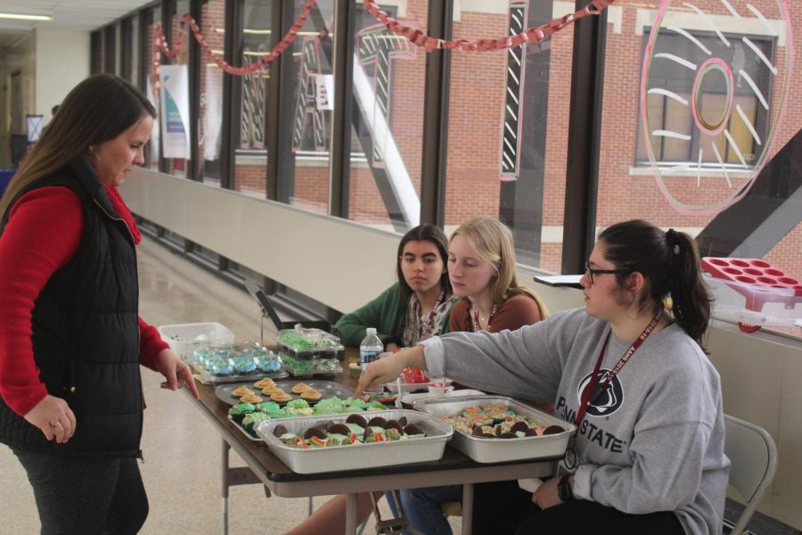 Seniors of last school year, Takera Jones, Bailie Newberry and Reagan Baker sell baked goods on the bridge for Girls League. They sold their homemade baked goods to Emily Bender. 
