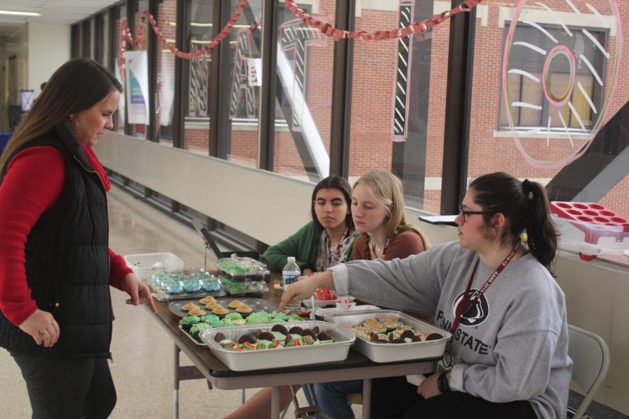 Seniors of last school year, Takera Jones, Bailie Newberry and Reagan Baker sell baked goods on the bridge for Girls' League. They sold their homemade baked goods to Emily Bender. 