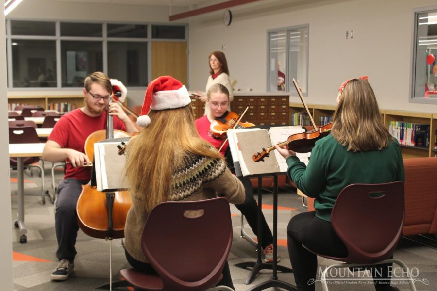 Entertainment for the Kids,  The string quartet entertains the families at the holiday party. The four students played many Christmas songs on their instruments. 