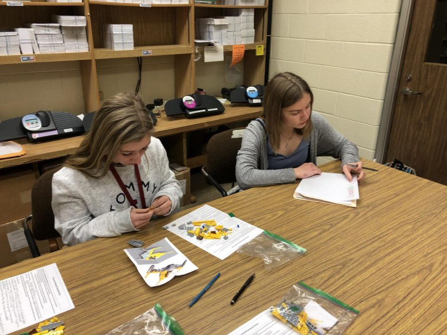 Junior Karenna Kauffman examines other junior, Cassie Kyle, who gets hard to work on her lego model. Kyle worked on her model in session one of Kauffmans expiriment. 