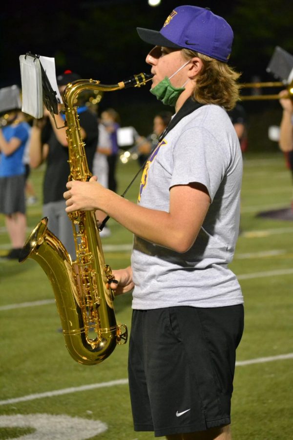 Almost game day! 
Senior Ryan Naglowsky Plays his tenor saxophone to the song Good Time. Anytime the band is not playing their instrument, they always put their mask back on.