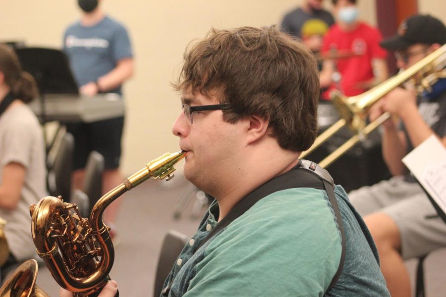 Senior Aiden Phillips warms up before rehearsal begins. Just like athletes, it is important for musicians to warm up in order to prepare themselves and their instruments for playing. 