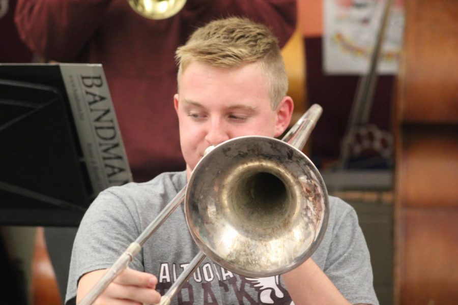 Sophomore Jacob Steinbugl plays the trombone during a jazz band rehearsal. The jazz band rehearses in the orchestra room at the junior high school. 