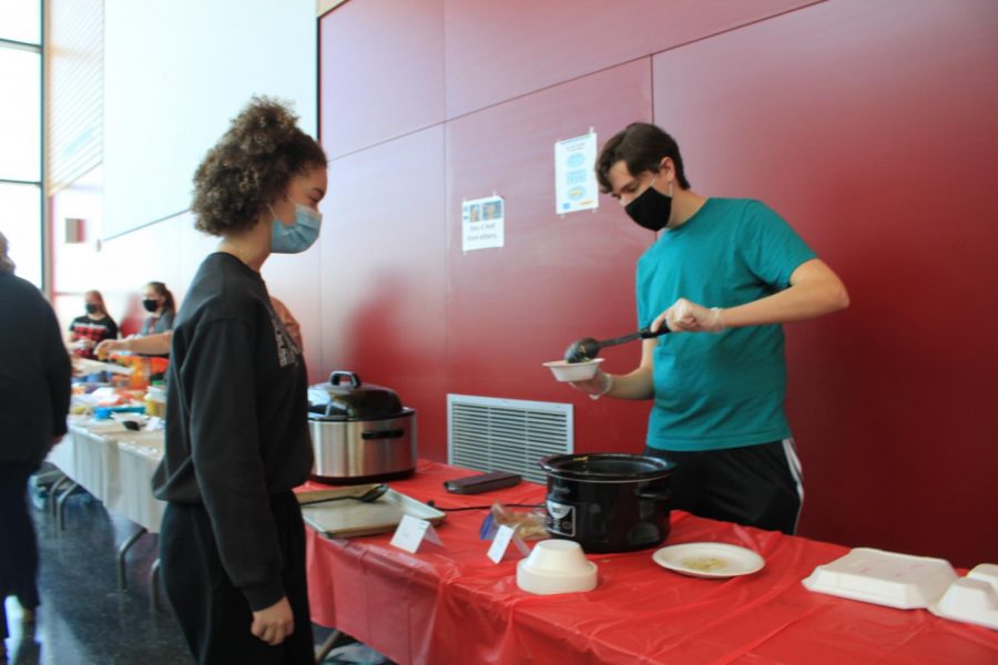 Senior Alex Thaler dips out food during the foreign language club (FLC) food event. During this event, FLC students made food from different country origins. The students then brought this food in to share with the school.