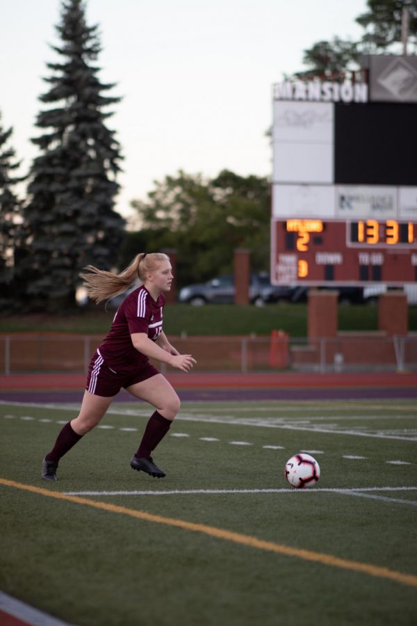 Serve! Junior Becca Dull goes to pass the ball. Girls soccer is only one of the many sports that use Mansion Park. 