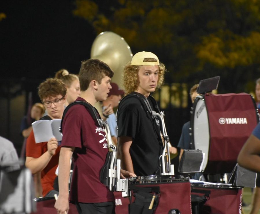 Left, right left Percussion members march around the field playing to their half time song.   