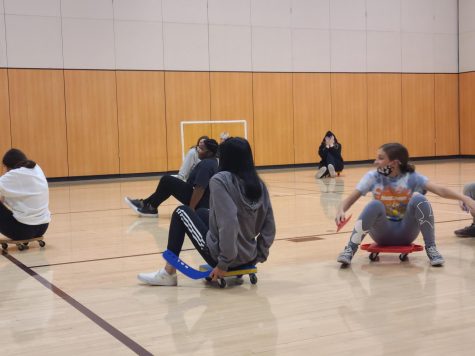 Rolling around 
Gym students play a game during gym class. They wore athletic attire during the game because it made it easier to play.