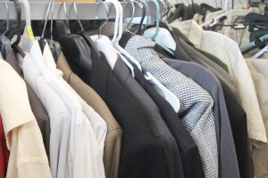 Dressing Formal. Suits and button ups are hung up on the racks. A variety of formal wear covers around half of the room.