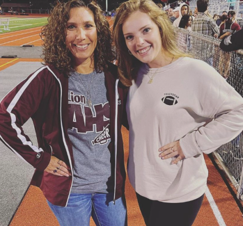 Coach Autumn Barry-Kyle poses with the new assistant coach at a football game.