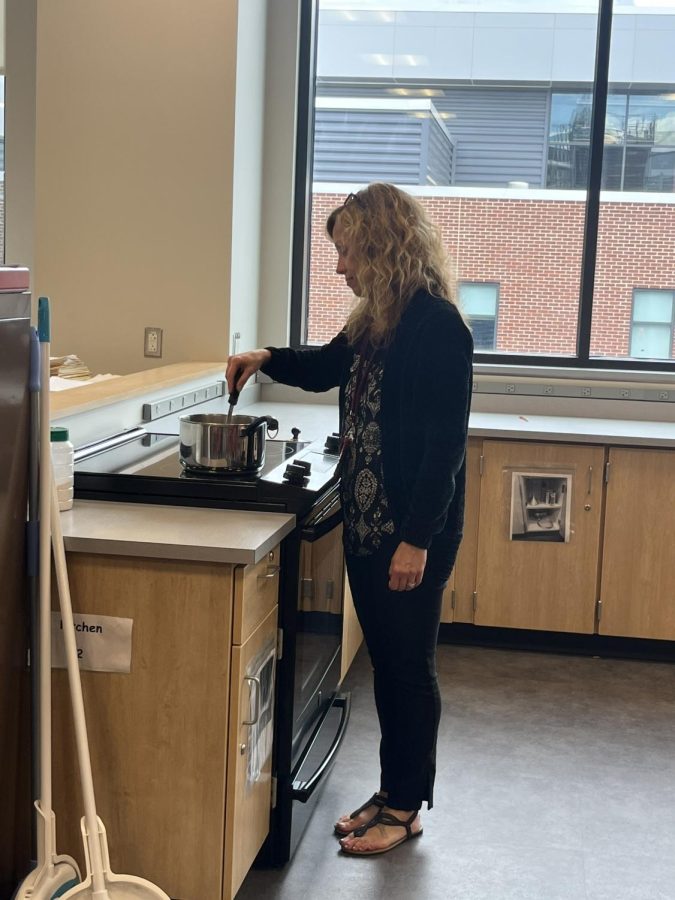 Stirring something up. 
Finnegan is at her stove top in her classroom. Finnegan was a substitute last year for cooking class, so she knows how to do most tasks already. 