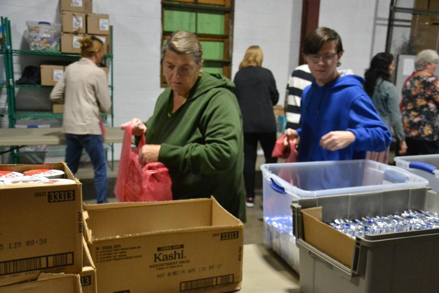 Making a difference. Volunteers fill plastic bags with food to supply elementary students with nutrition for the weekends on Wednesday, Sept. 28. Helpers gathered in a warehouse on Beale Ave. Tenth grader Nevin Kelley (on the right) contributes to the efforts.