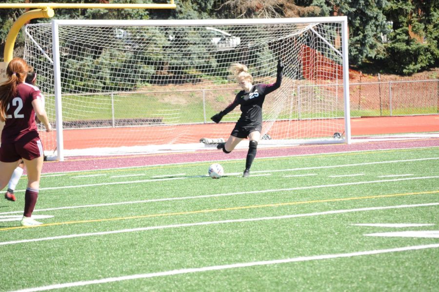 Defense. Senior Quinn DeAntonio kicks the ball away from the goal in order  to keep the other team from scoring. 