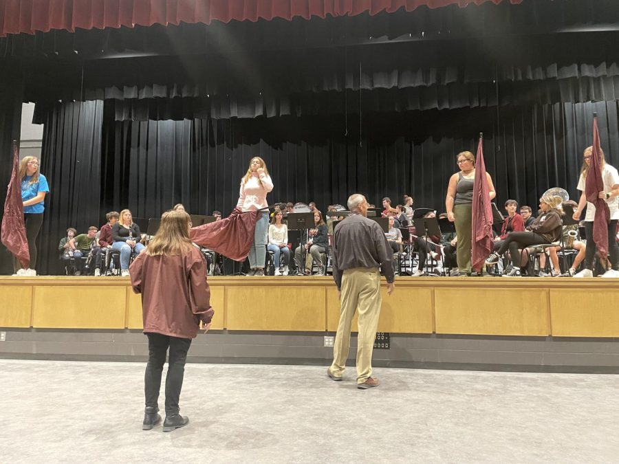 Spacing it out. Larry Detwiler shows the senior silk captain, Kiara Flanagan, where she will be standing the night of the concert. Flanagan is the only senior on the silk squad.