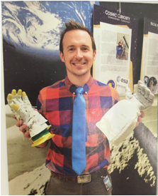 Spaced out. Astronomy adviser James Krug holds two astronaut hands. Krug has taught astronomy for the past few years at AAHS. Krug is one of the members of the climate and culture squad.