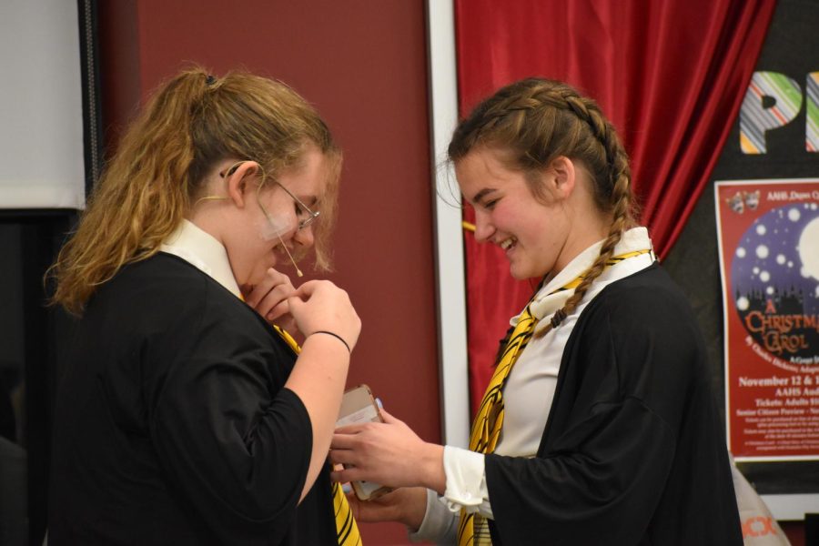 Finishing touches. Junior Claire Piper fixes senior Christina Dicus tie. Piper and Dicus have become close through acting. 