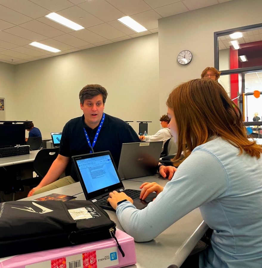 Communication is key. Business teacher Jesse Frailey helps a student complete an assignment. Helping students understand a topic is important for success.