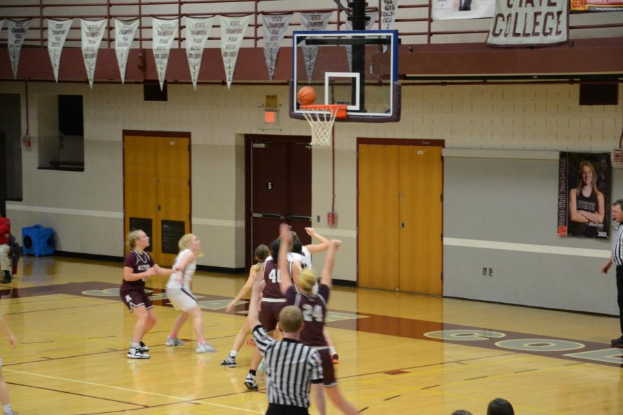 Three more points. Senior Harley McGirk shoots and makes a basket from the three point line during the State College game. Two of her teammates follow the shot in hopes of getting the ball if she doesnt make it. 