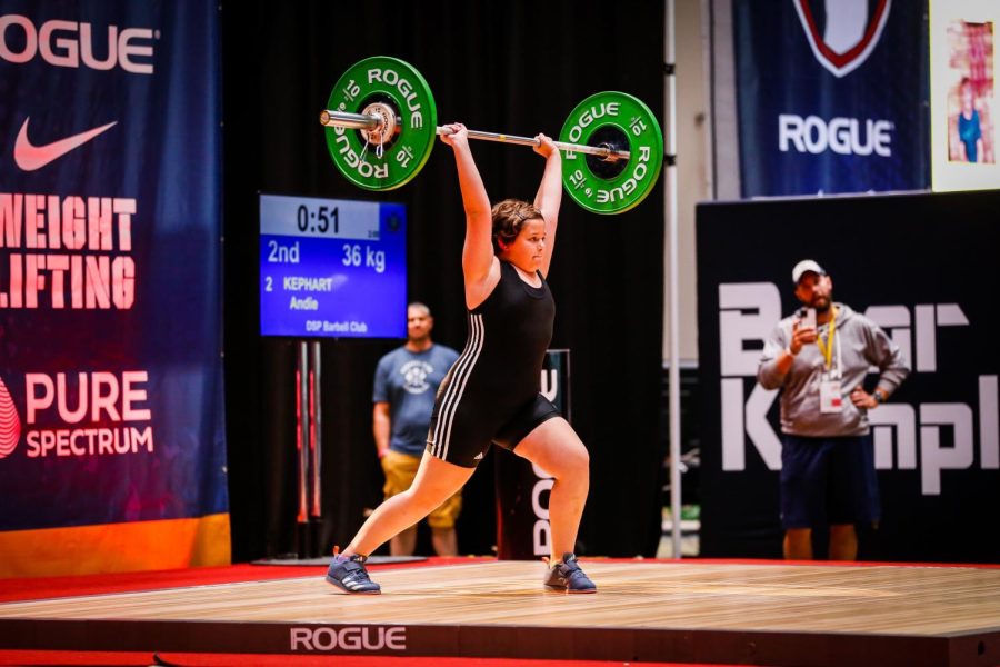 Lifting. Andie Kephart performs a lift called a clean and jerk at 2021 Nationals in Detroit, MI. Kephart has been lifting at Dormans Sports Performance with the barbell club for three years. 