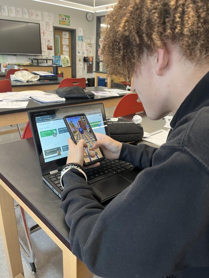 Lamar Franklin hides his phone behind his Chromebook.  Chemistry teacher Teresa Rubine would never allow a cell phone in class according to school policy but allowed this photo.  
