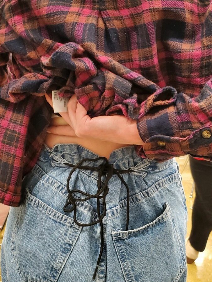 Sophomore Brooke Everhart showcases her stylish outfit adorned with a shoelace. Shoelace belts are also trending this year. 