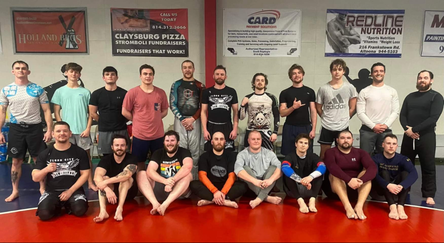 The+students+of+Jiu+Jitsu+pose+for+a+picture+with+coaches.+