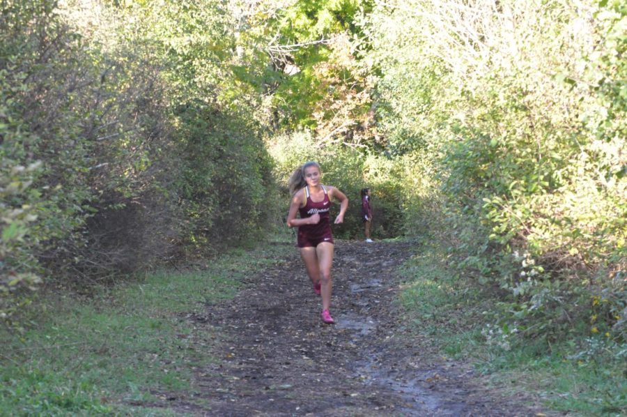 Climbing Up senior Reese Wilber makes her way up what teammates call bus garage the steepest hill on the home course.