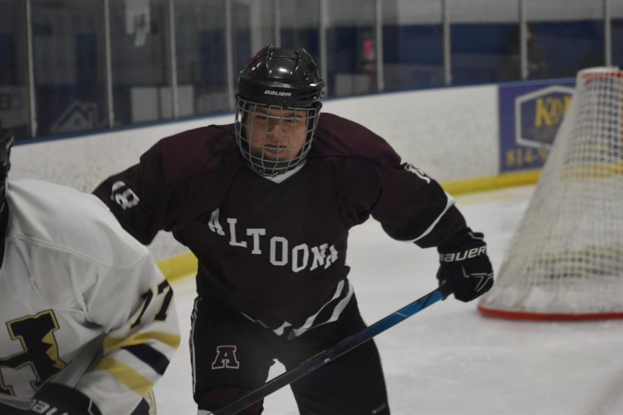 Watch out. Senior Colin Monahan watches as he bounces the puck off the side of the rink to get it passed the opponent. Another Altoona player took the pass and made the goal.