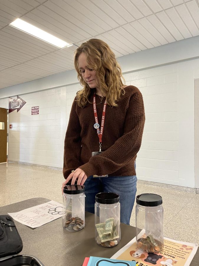 Every penny counts. Sophomore Andrea Slusser donates $5 to one of the jars. Pennies for Pets ran from March 13 to March 17. 