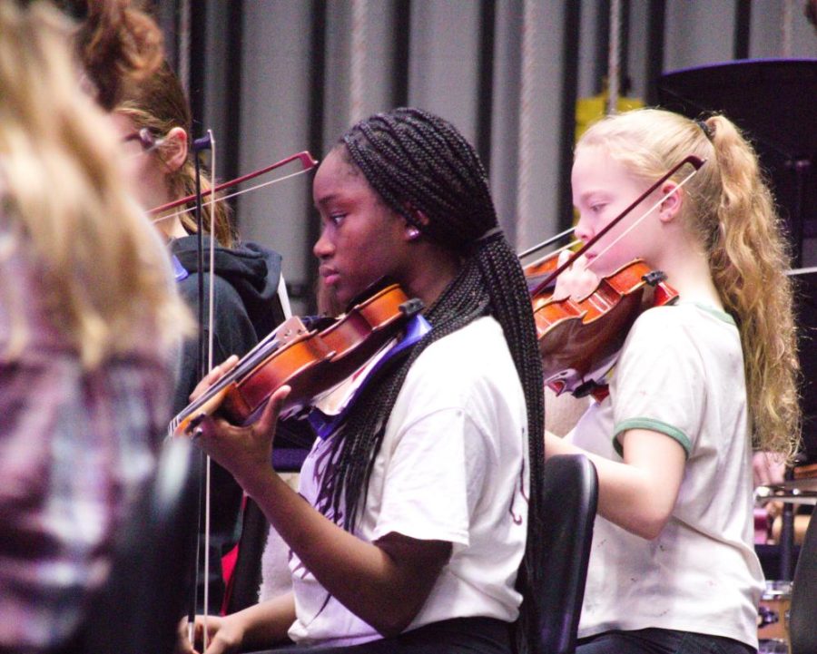 Practicing. Freshman Hannah Owulade plays the violin during rehearsal for the holiday concert. The symphonic orchestra is now preparing to play the String Spectacular.