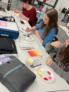 Painting! Freshmen Miley Naugle, Melissa Krainer and Madison Aboud taking part in the fun day. This fun day consisted of popcorn and painting. 