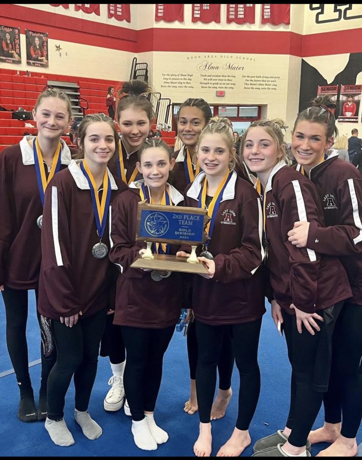 Say+Cheese+The+gymnastics+team+holds+the+trophy+at+States+competition.