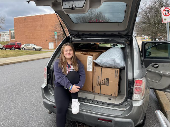 Helping out. Freshman Rylee Bush sits with boxes full of clothes for Rachels Closet. 