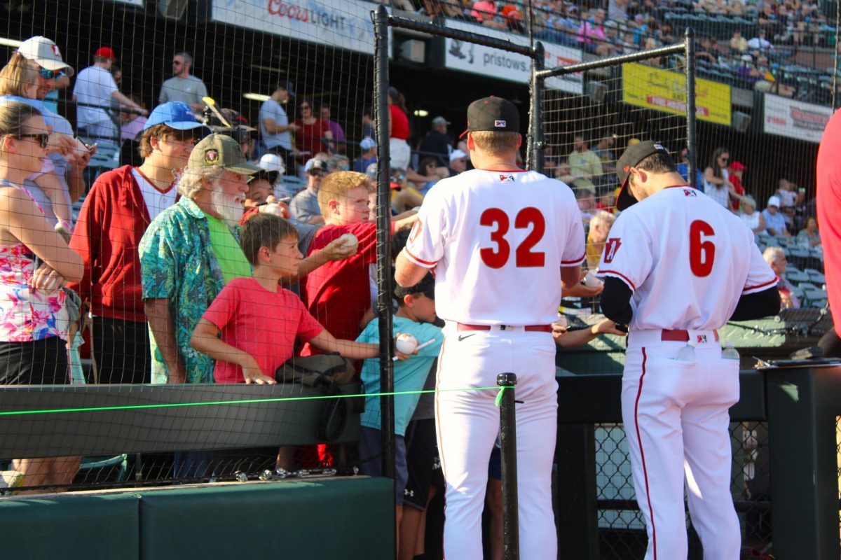 Fan favorites. Cameron Junker and Grant Fort sign baseballs for fans before the game starts. Fans line up at the fence as soon as the gates open to the crowd. 
