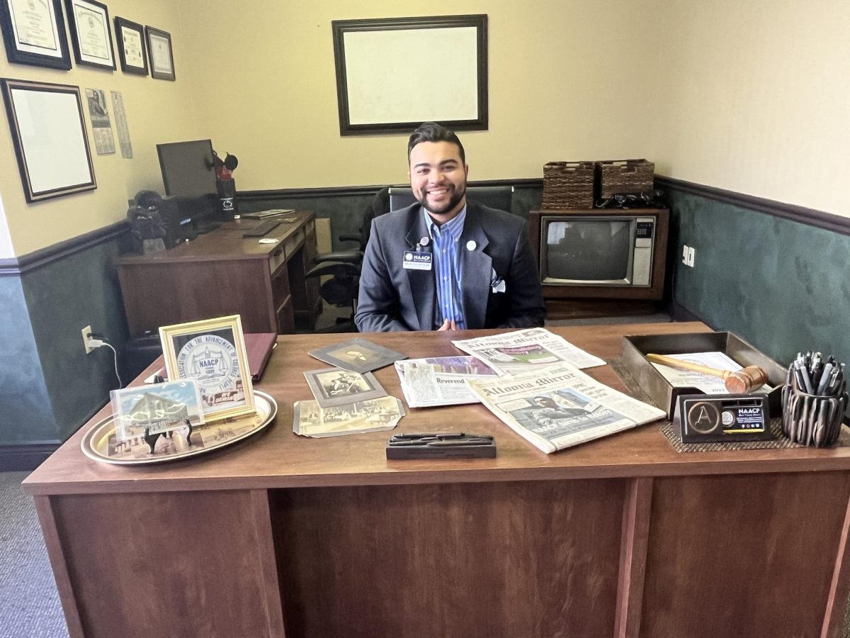 Leading the way. Altoona alumnus Andraé Holsey shows off history of the NAACP. Holsey has been the branch president since 2021. 
