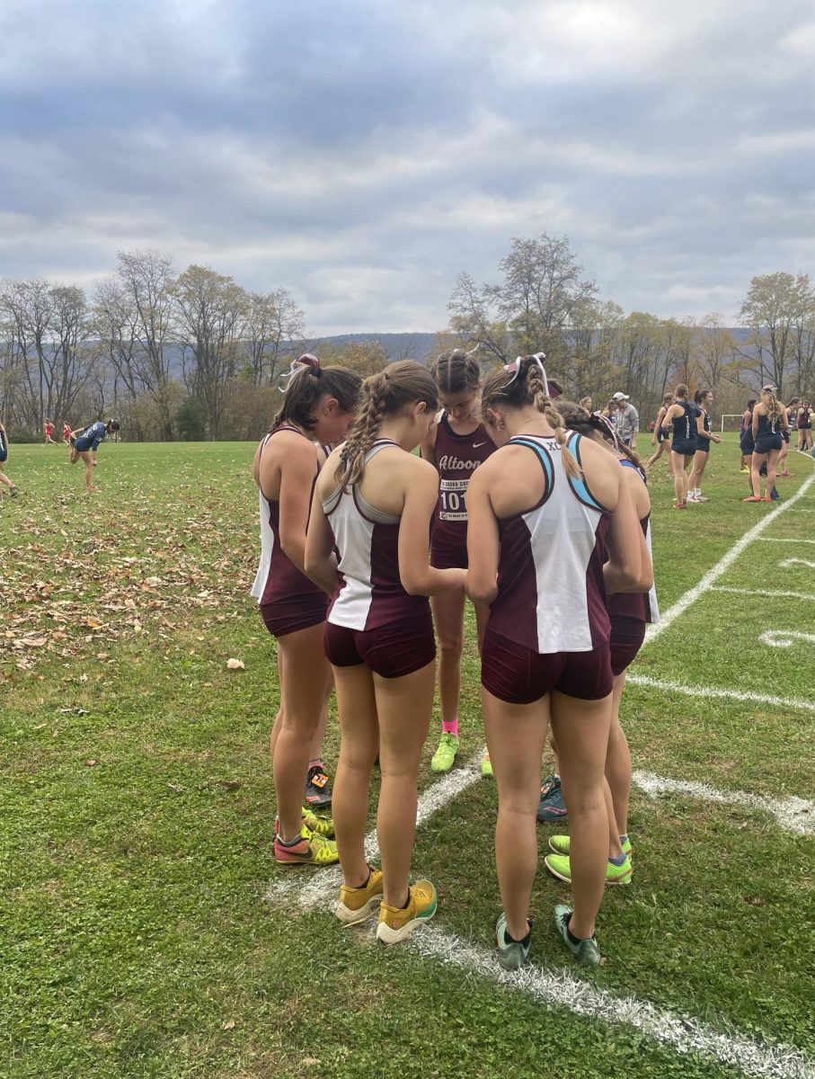 Locked In. The varsity girls cross country team huddles together before the start of their race.