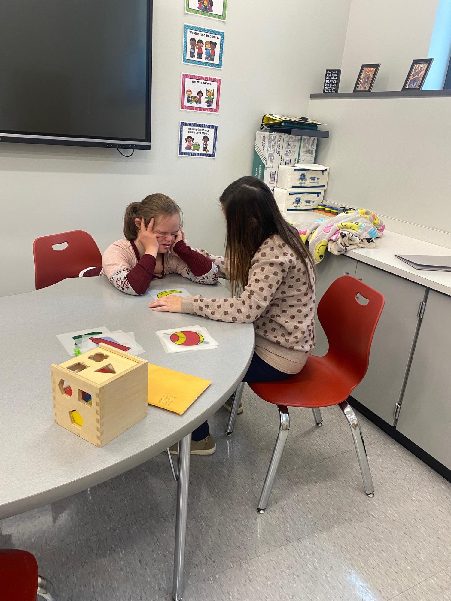 A helping hand. Kaylee Matish helps calm a student down after a sudden adjustment. The student was crying because of being moved without warning but was comforted by Matish.