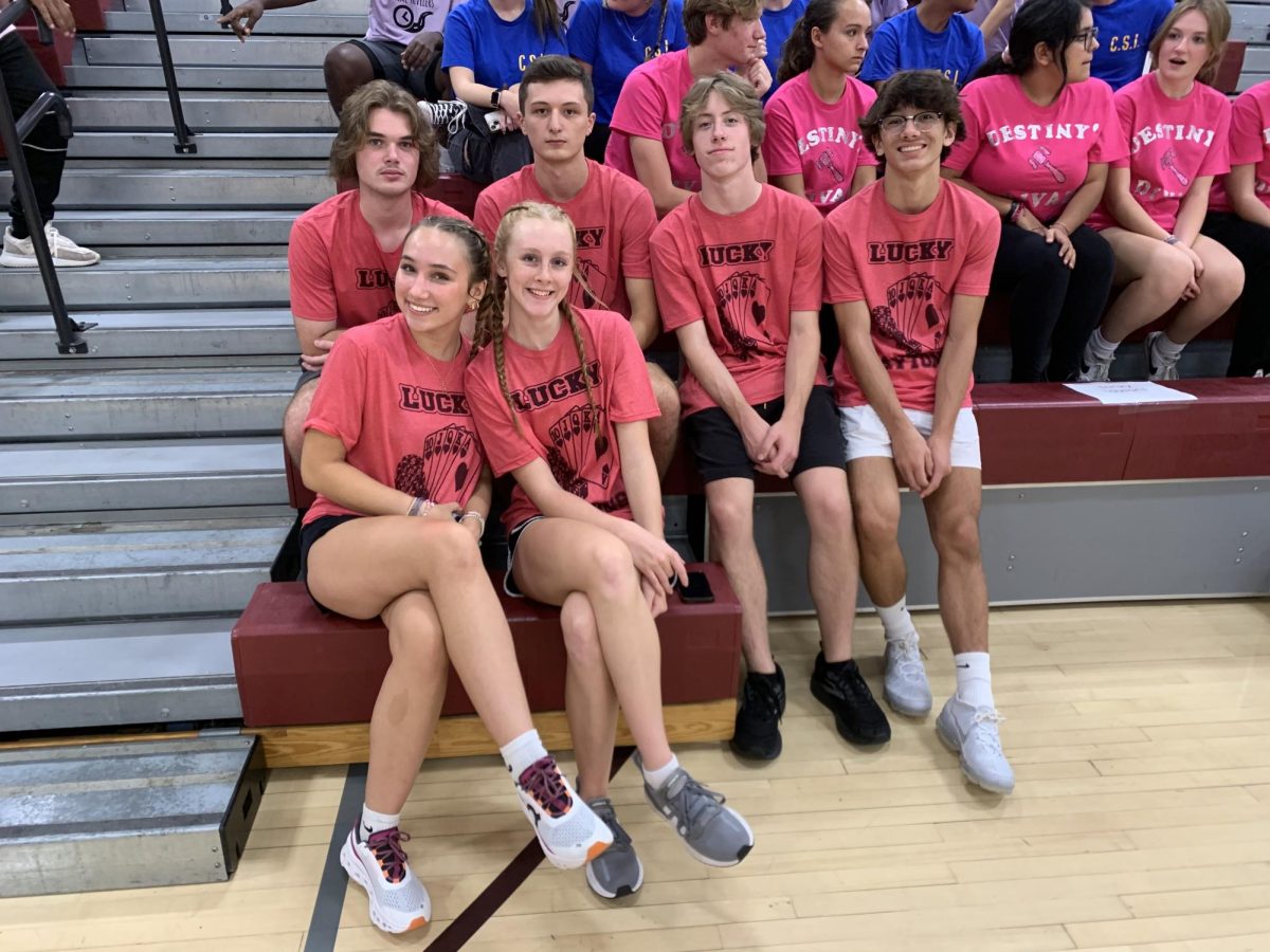 Lucky Laytons. Aleah Layton, representing Sparkle cheerleading, smiles with her homecoming team in the bleachers. On Oct. 3, homecoming candidates and their teams participated in different activities in the fieldhouse beginning at 7 p.m. Admissions cost was $2 per person.
