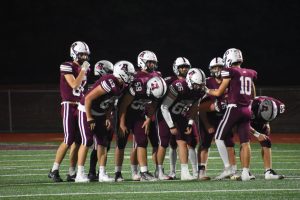 Ready to win! The football team huddles before a play.