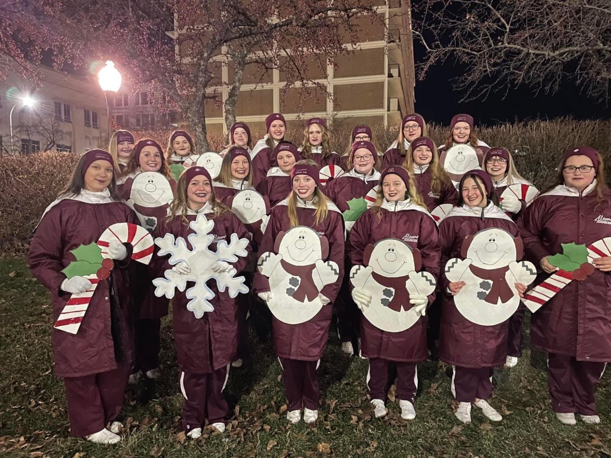Its+Christmas+time.+The+majorettes+and+silks+pose+for+a+picture+before+the+2022+Christmas+parade+in+downtown+Altoona.+The+band+presented+spectators+with+Santa+at+the+end+of+the+parade.+