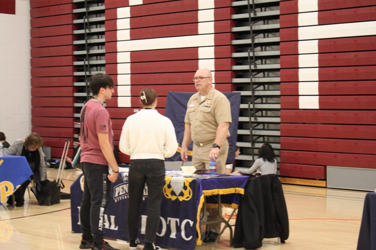 Students Emma Bechtel and William Wertz talk to the Naval Academy Recruiter at the opportunity fair. Wertz plans on going to the Army and Bechtel plans on going to college and becoming an officer in the Navy. 