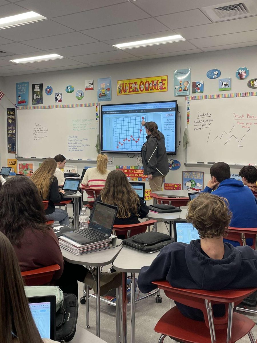American history. Makenzie Negris American history class learns about the stock market crash. Students took notes on their Chromebooks as Negri described a graph on the board.