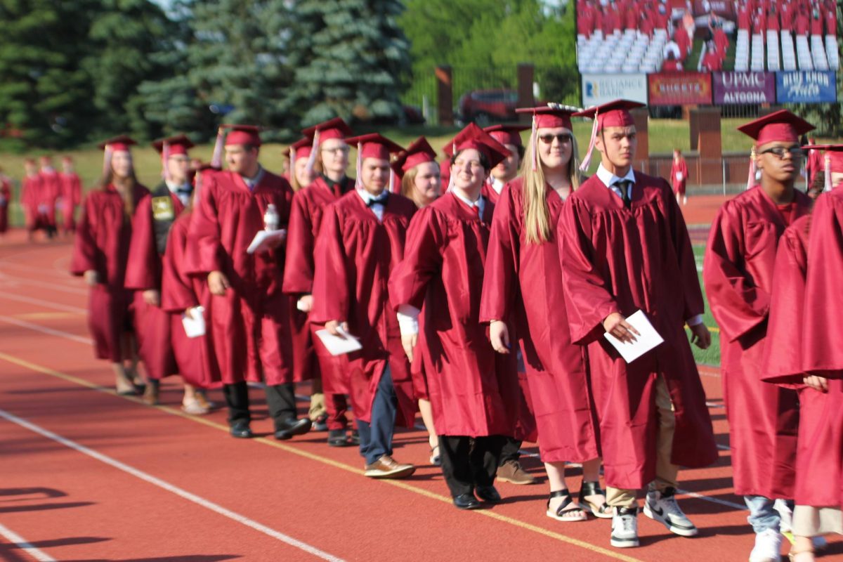 Senior class of 2023 walks the track at Mansion Park during graduation.
