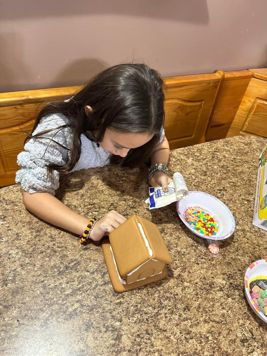 Christmas crafts. Elementary school student Alexis Shultz focuses in on her gingerbread house decorating. Her family has decorated a gingerbread house every year, for five years. 