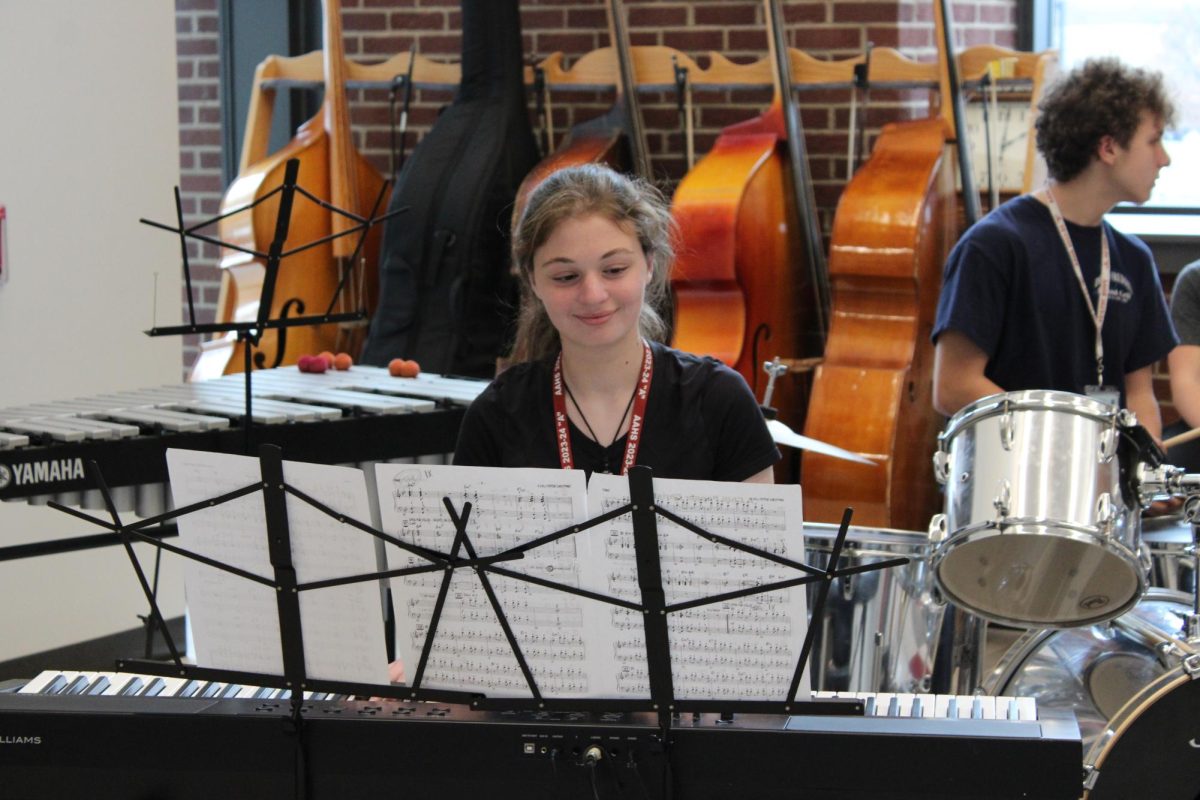 In the moment. Sophomore Isabella Abbott takes a moment to enjoy rehearsal in the week leading up to their holiday concert. 