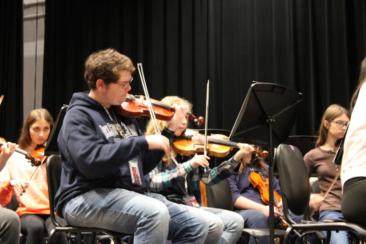 Teamwork. Orchestra members tune before practice on Dec. 6. 