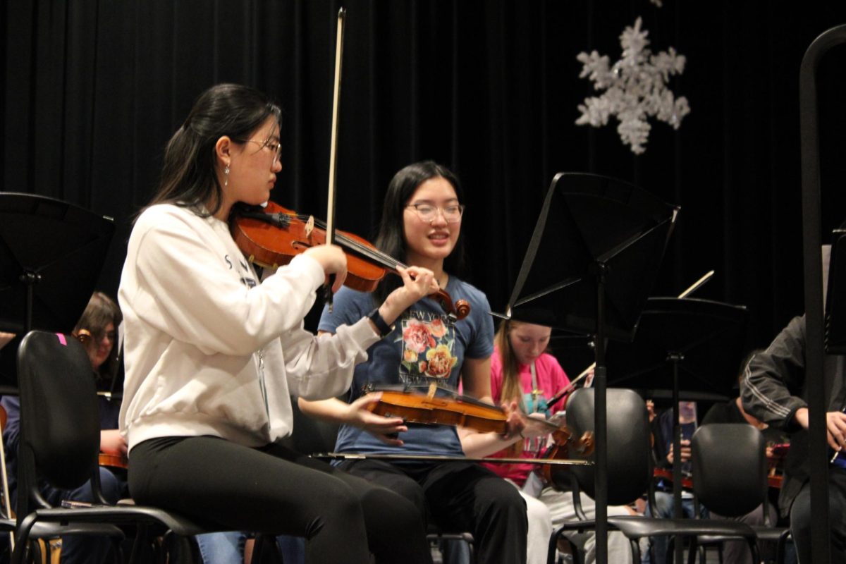 Getting Ready. Juniors Eileena Guo and Lavendia Guo prepare before rehearsal for the symphonic orchestra concert. Both sisters play the violin.
