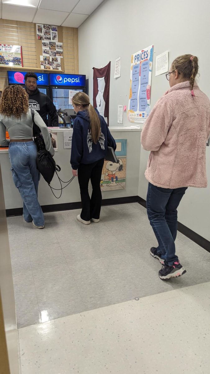Students wait in line to check out at the school store. The new system is up and running for students who want to use card.